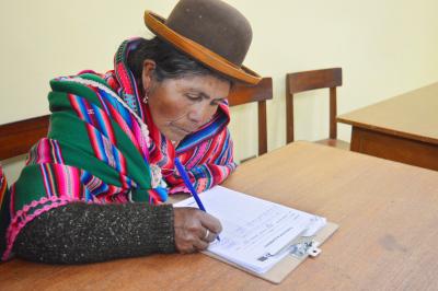 Indigenous Woman signs in to a community workshop